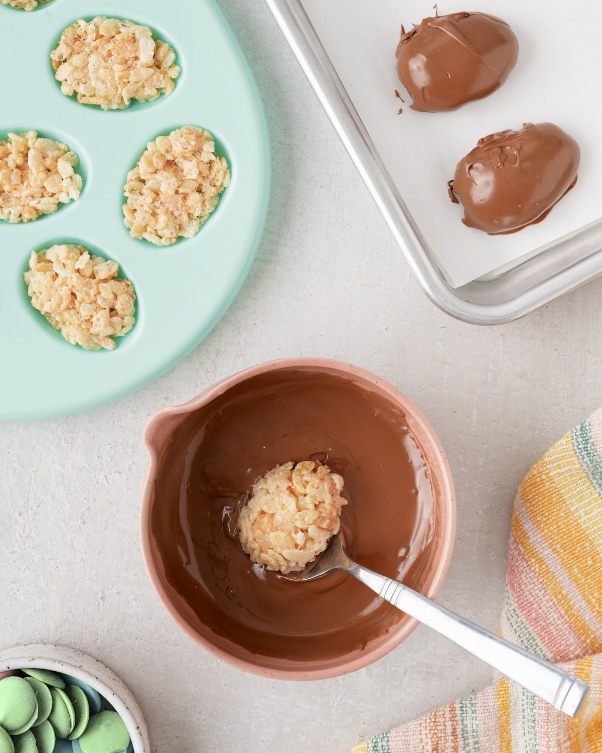 Dipping Rice Krispie eggs in melted chocolate