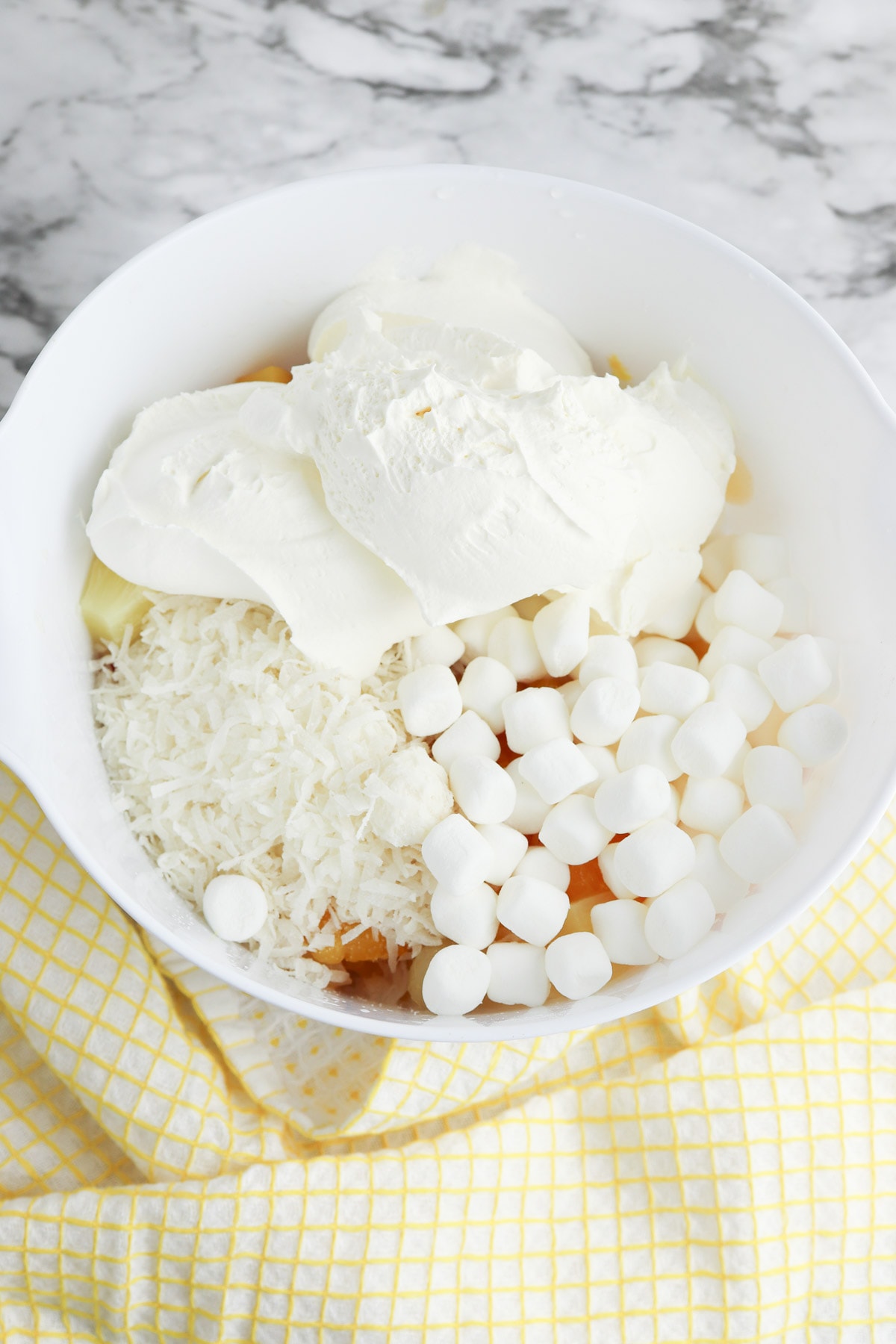 Coconut and Cool Whip added to white bowl