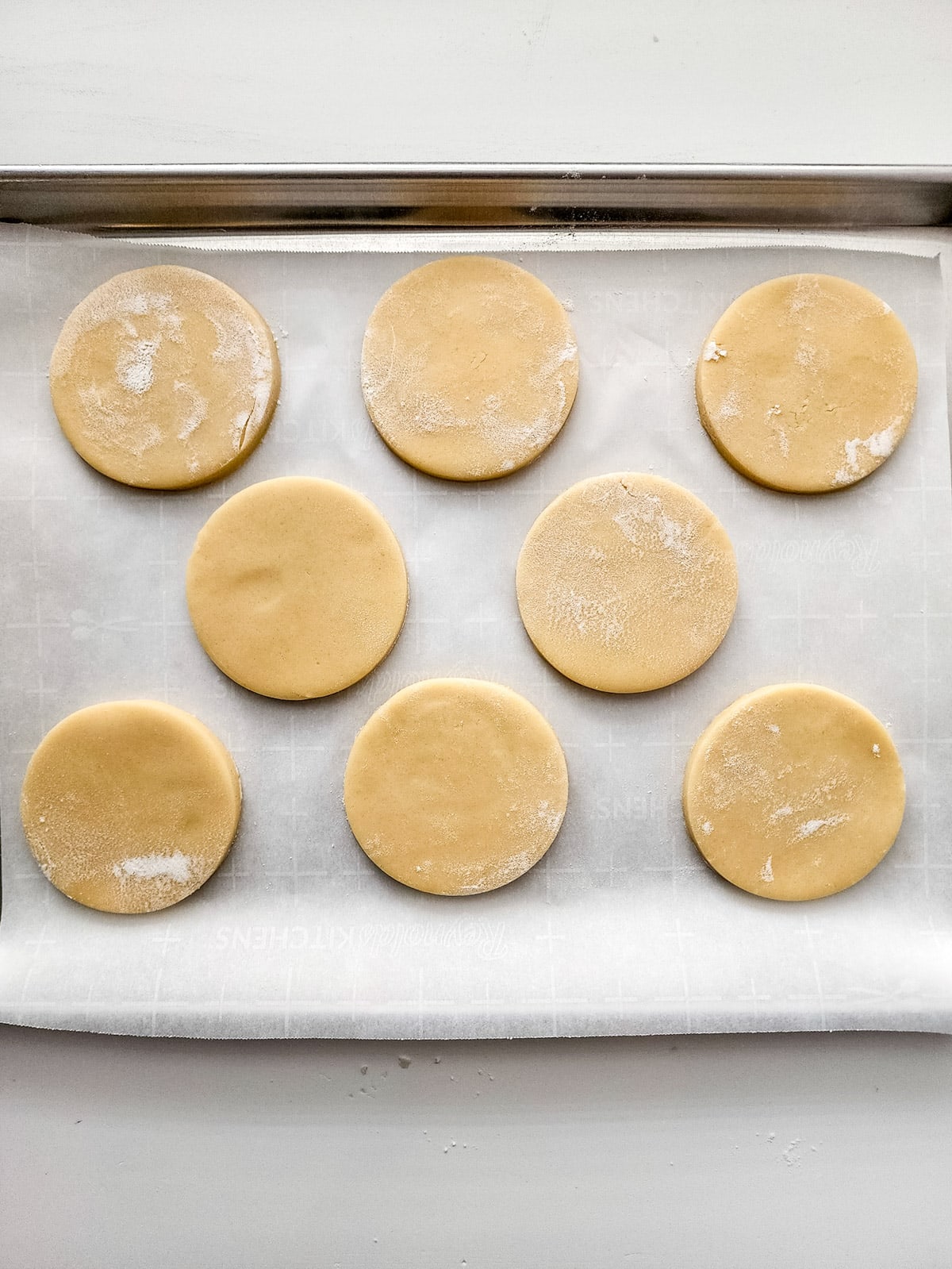Cookies cut into circles on parchment paper
