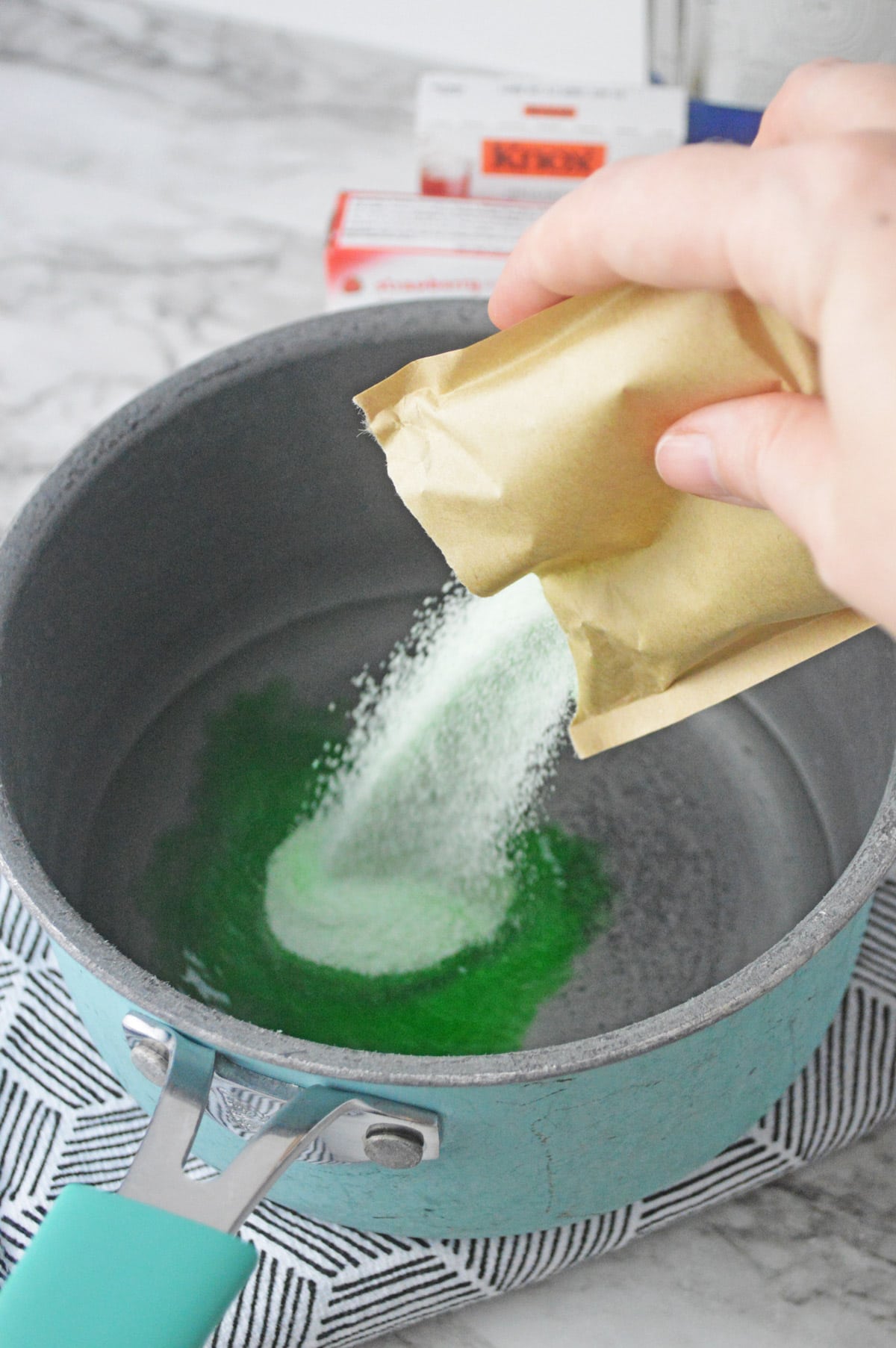 Adding green jello mix to water