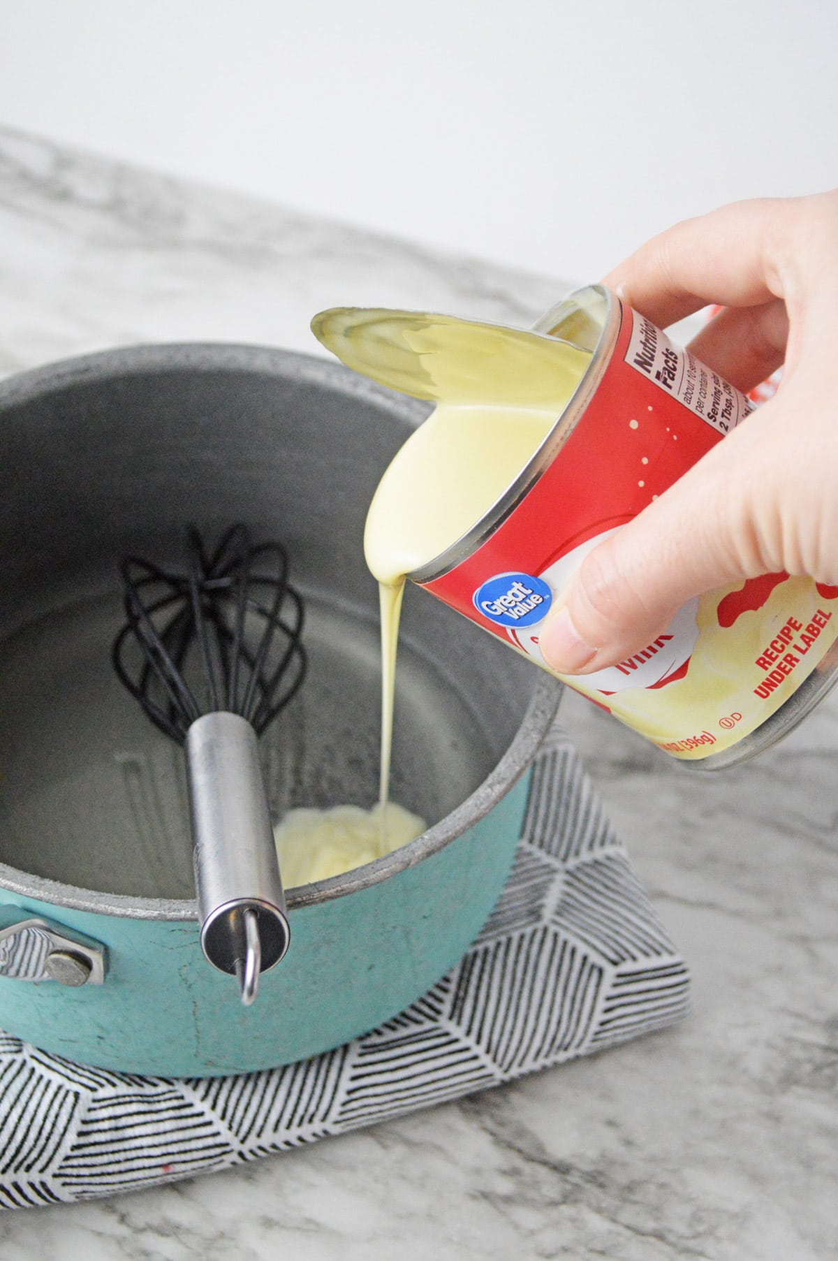 Adding condensed milk to saucepan with gelatin and water
