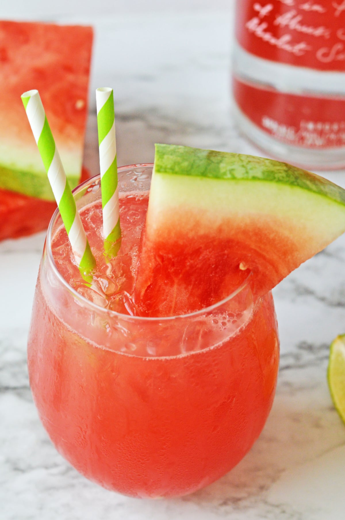 Watermelon crush cocktail with watermelon slice and green striped straws