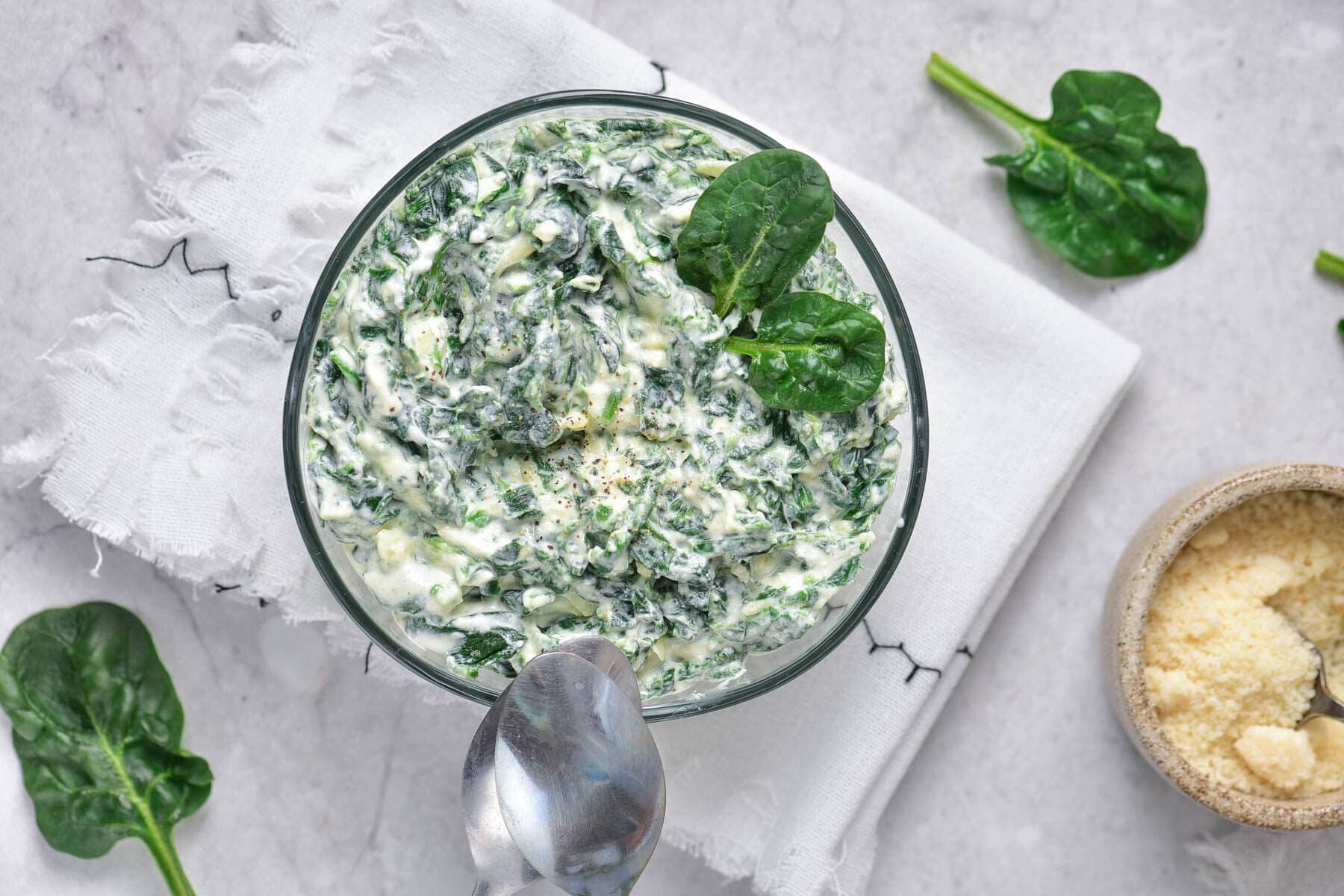 Cold spinach dip with spoons on white towel