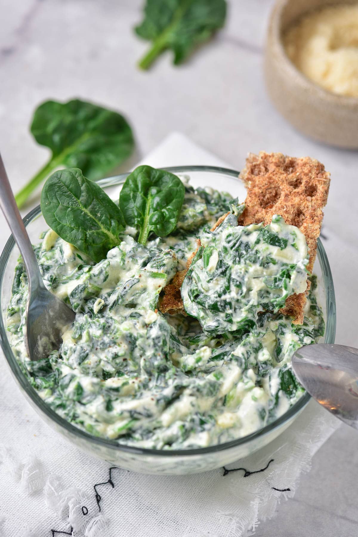 Cold spinach dip in bowl with cracker