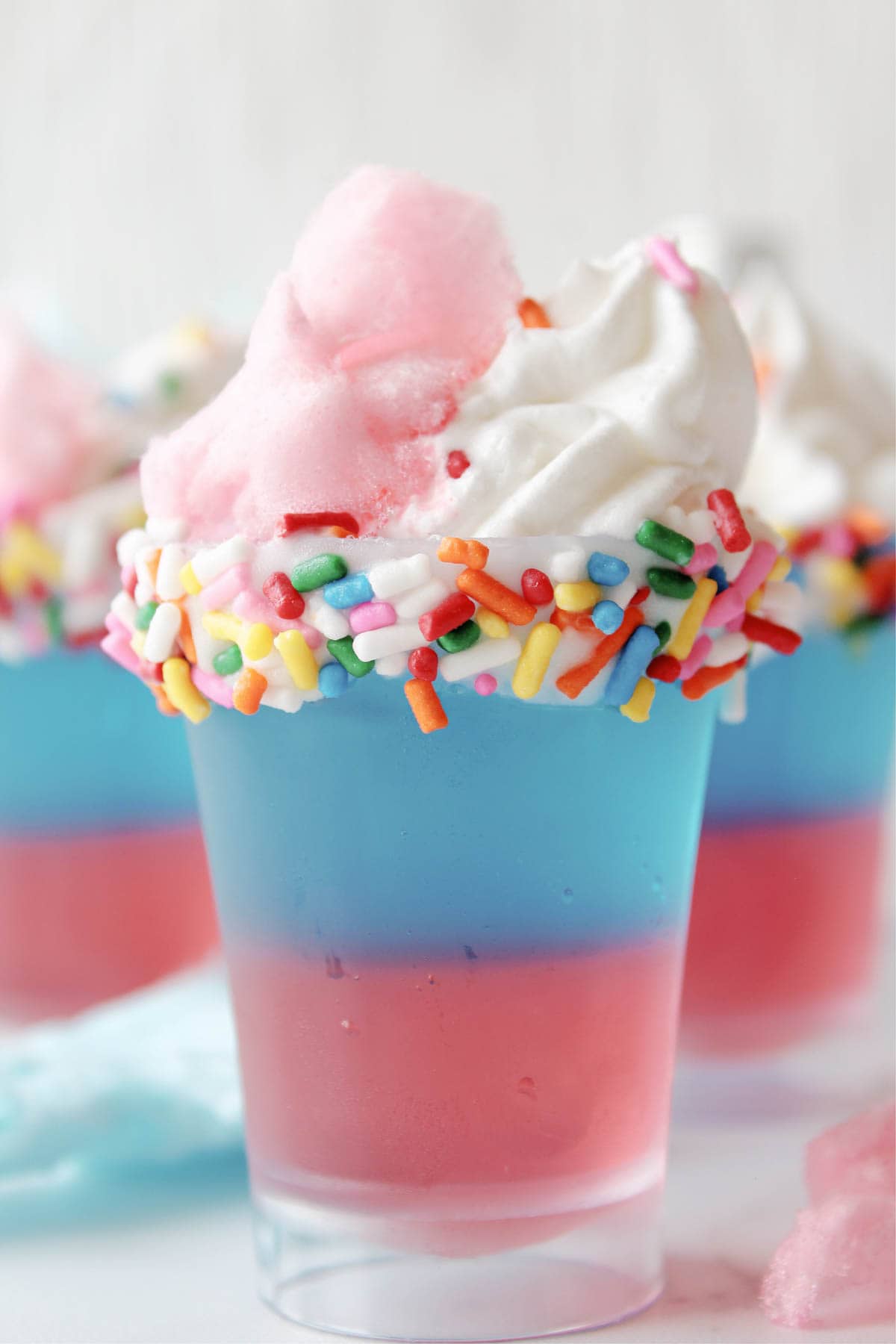 Cotton Candy Jello Shots topped with whipped cream and cotton candy