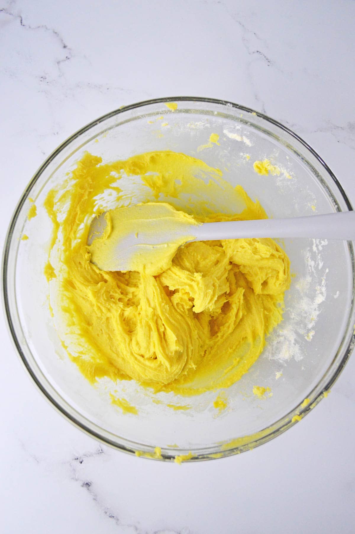 Lemon cake mix with eggs and butter in glass bowl