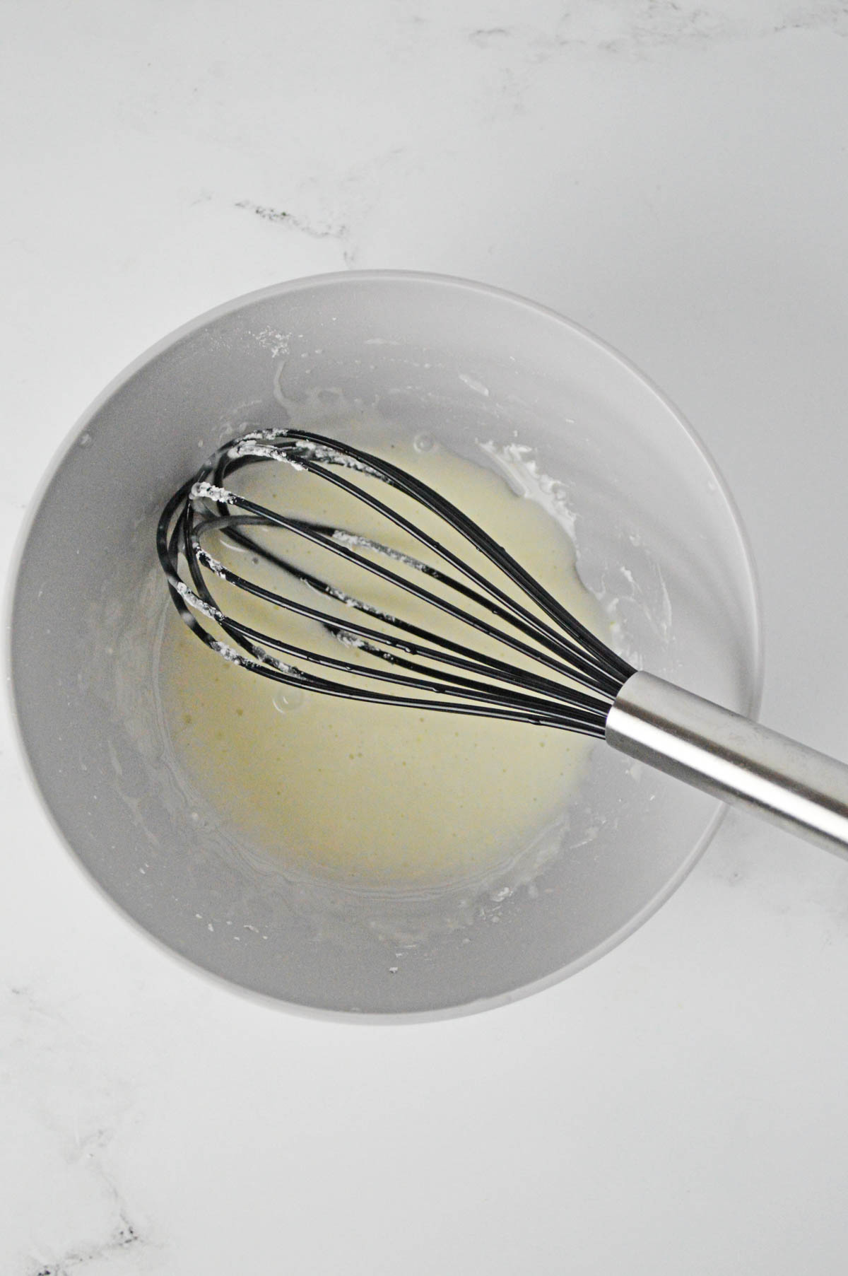Powdered sugar and lemon juice in mixing bowl