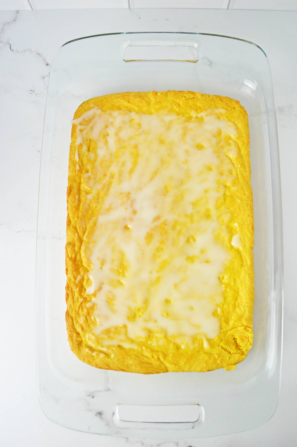 Lemon bars uncut with glaze poured over the top