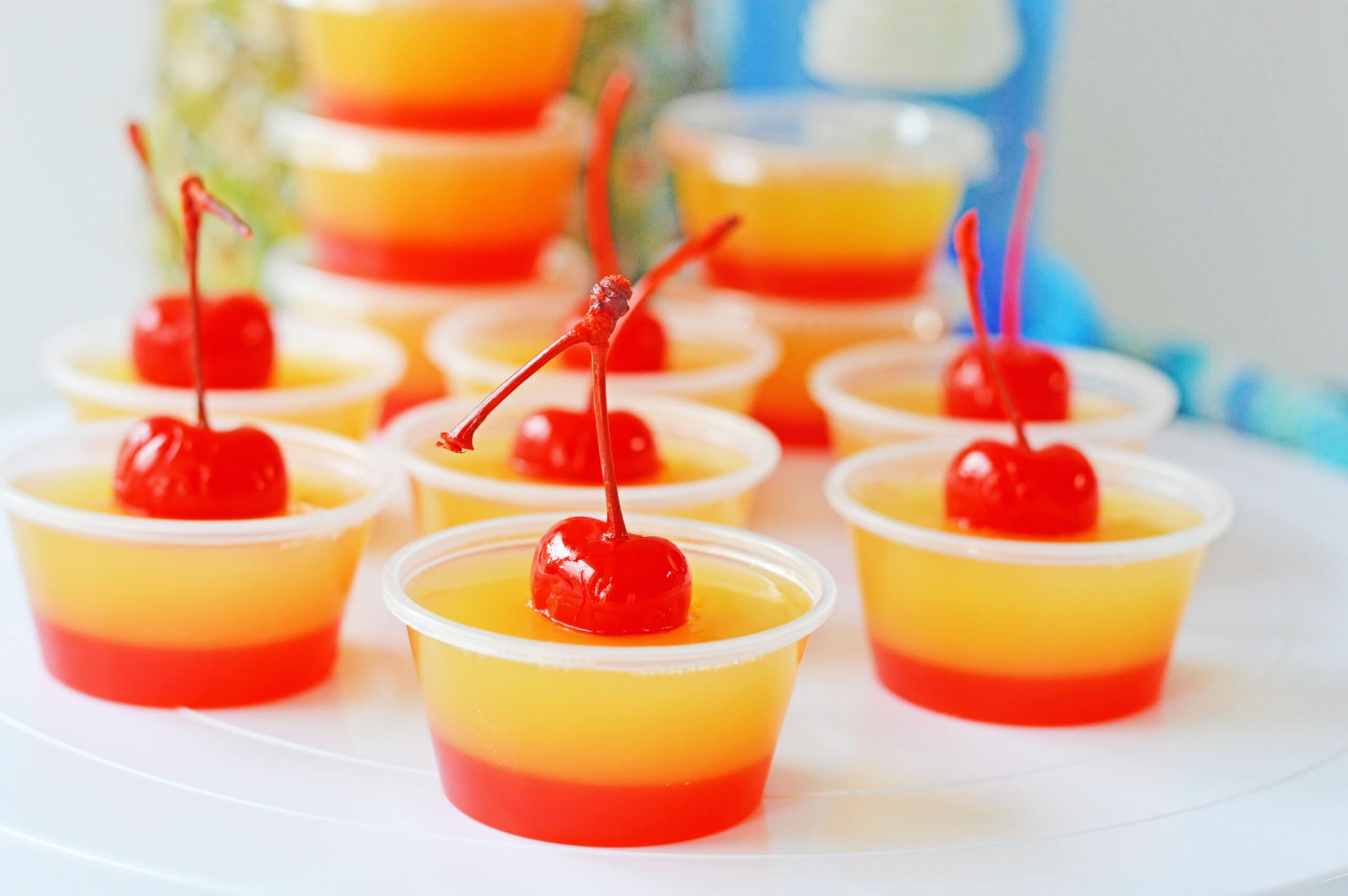 Red and yellow jello shots with cherries