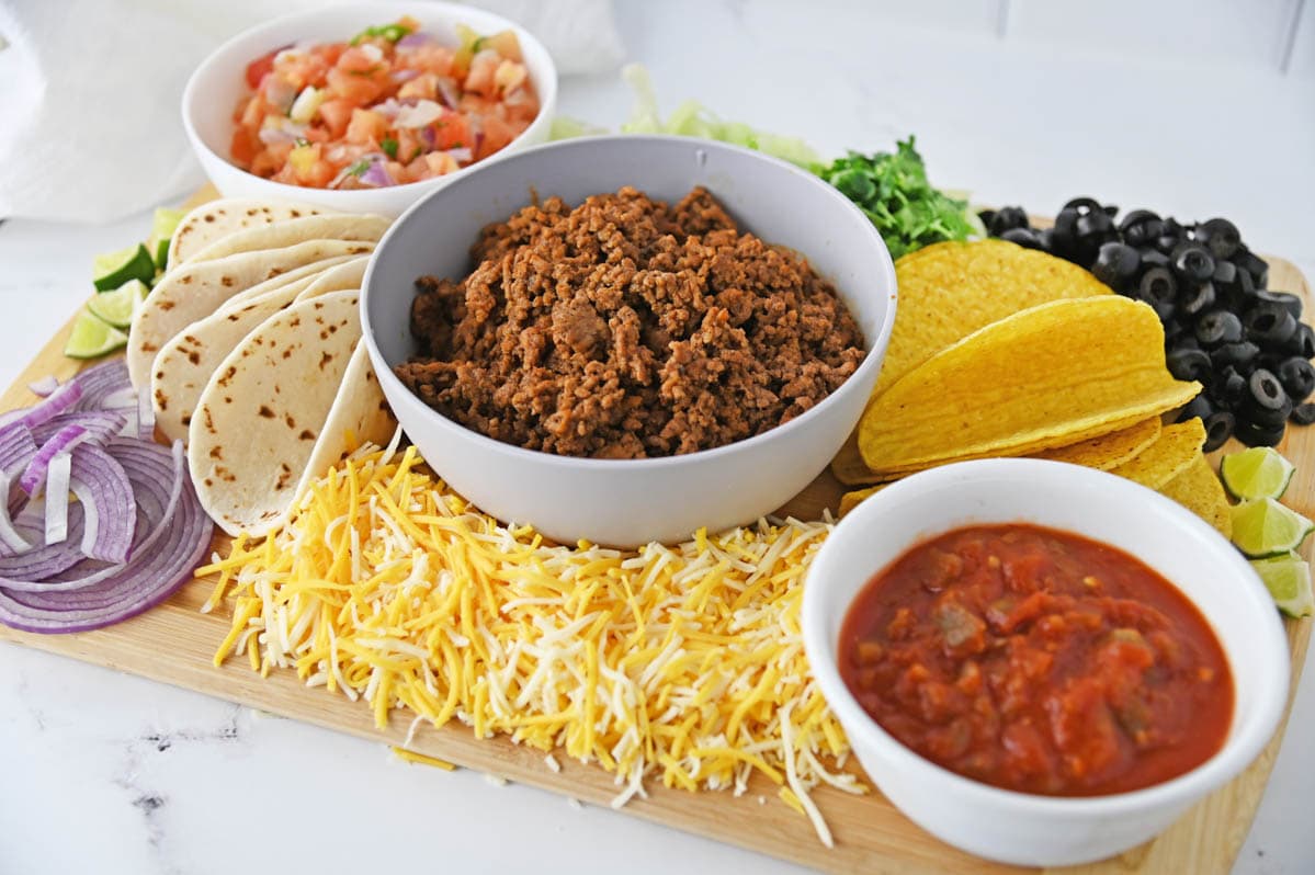 Wooden board with ingredients to make tacos