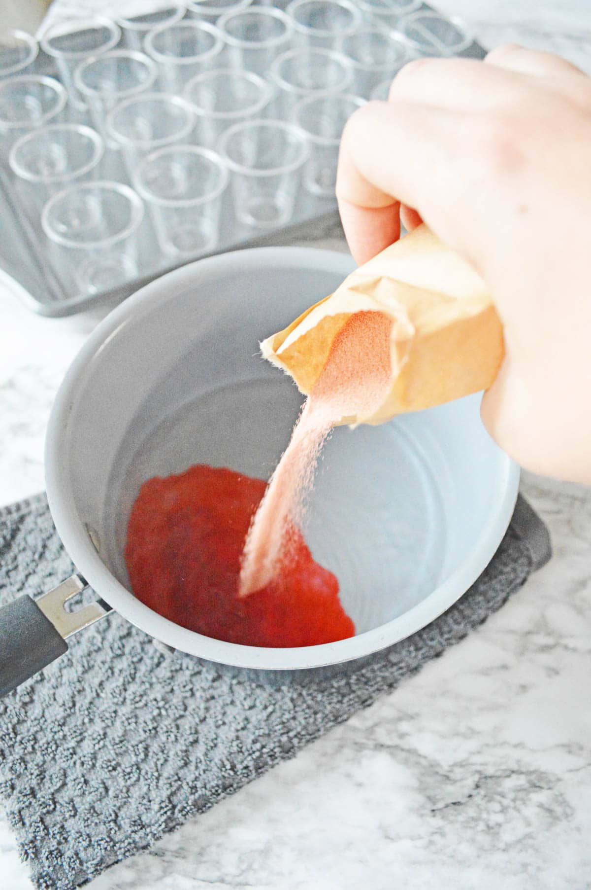 Pouring red jello into saucepan