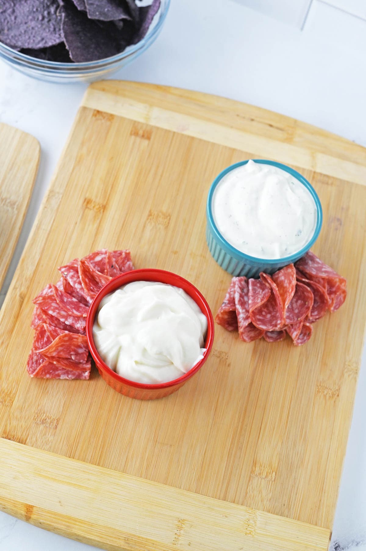 Meat added to charcuterie board around dip