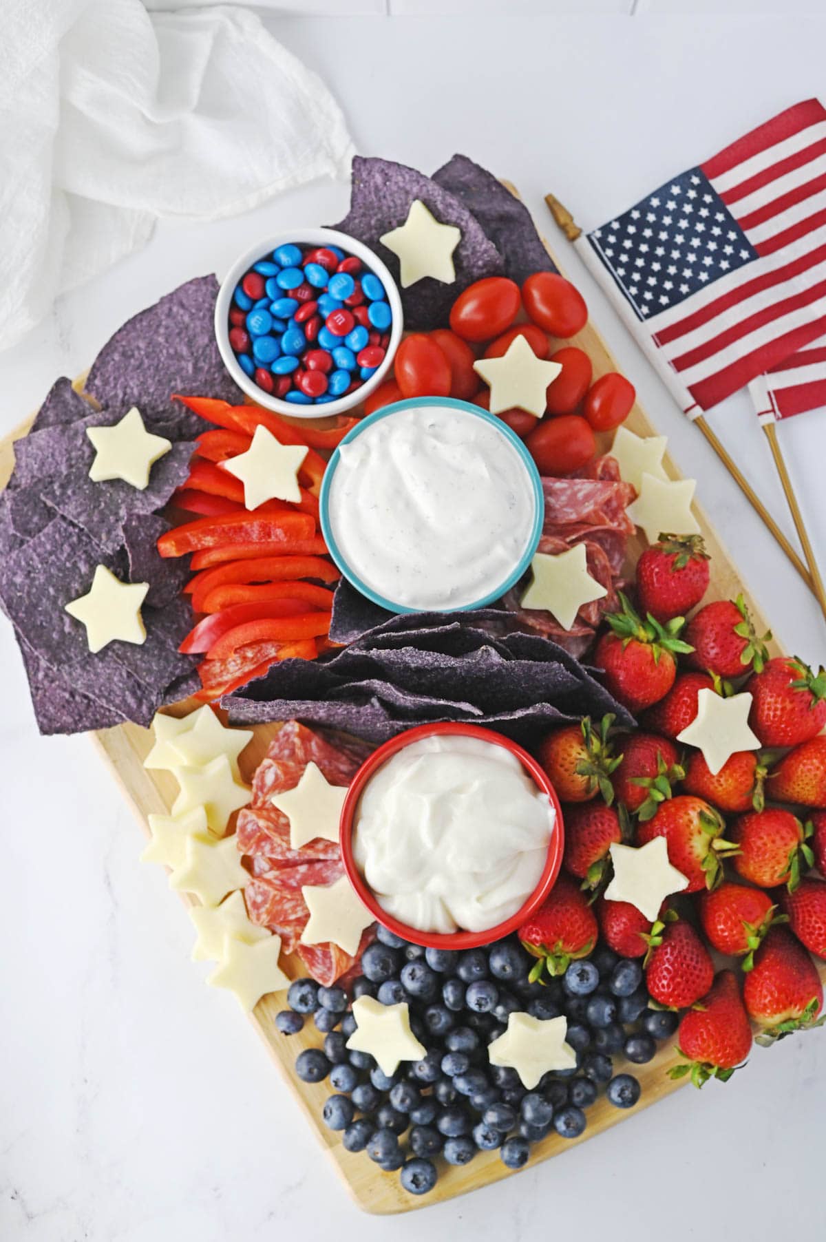 Charcuterie board filled in with red, white and blue food