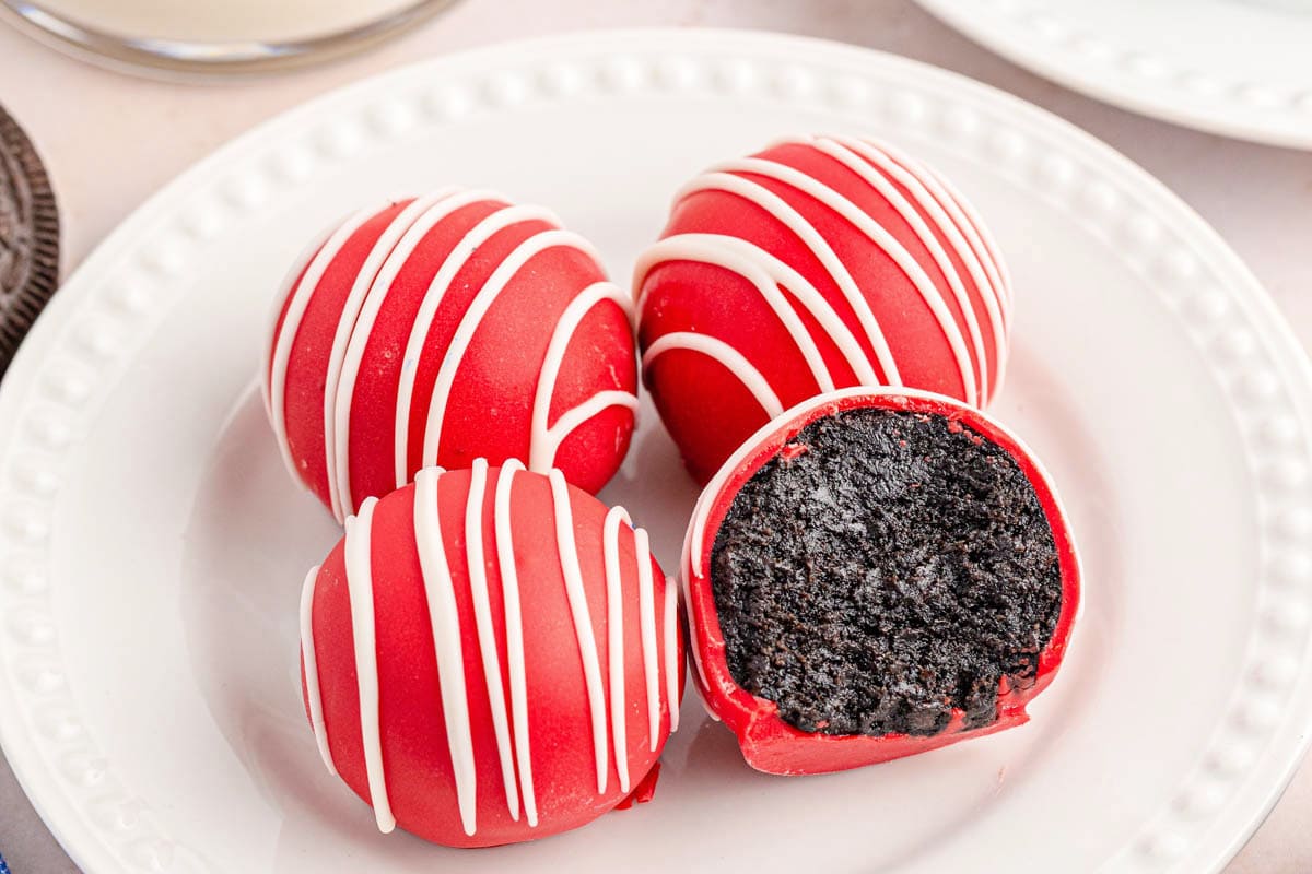 Red cake balls, one with a bite take out