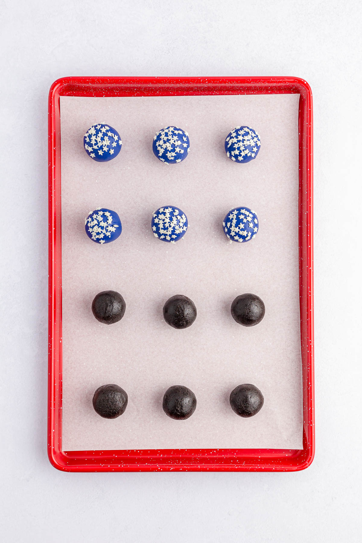 Oreo balls on baking sheet plain and with blue chocolate and stars