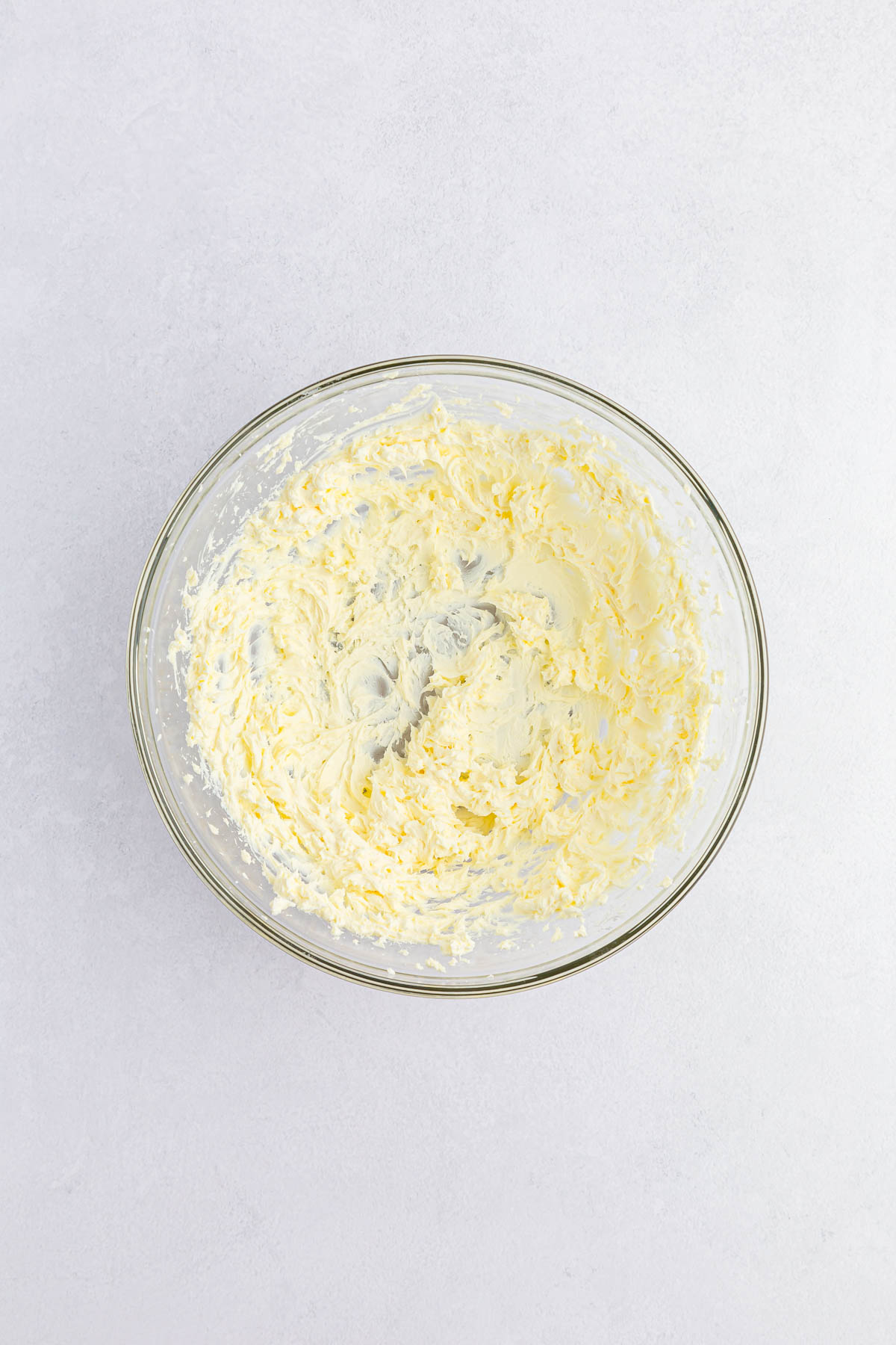 Cream cheese beaten in glass mixing bowl