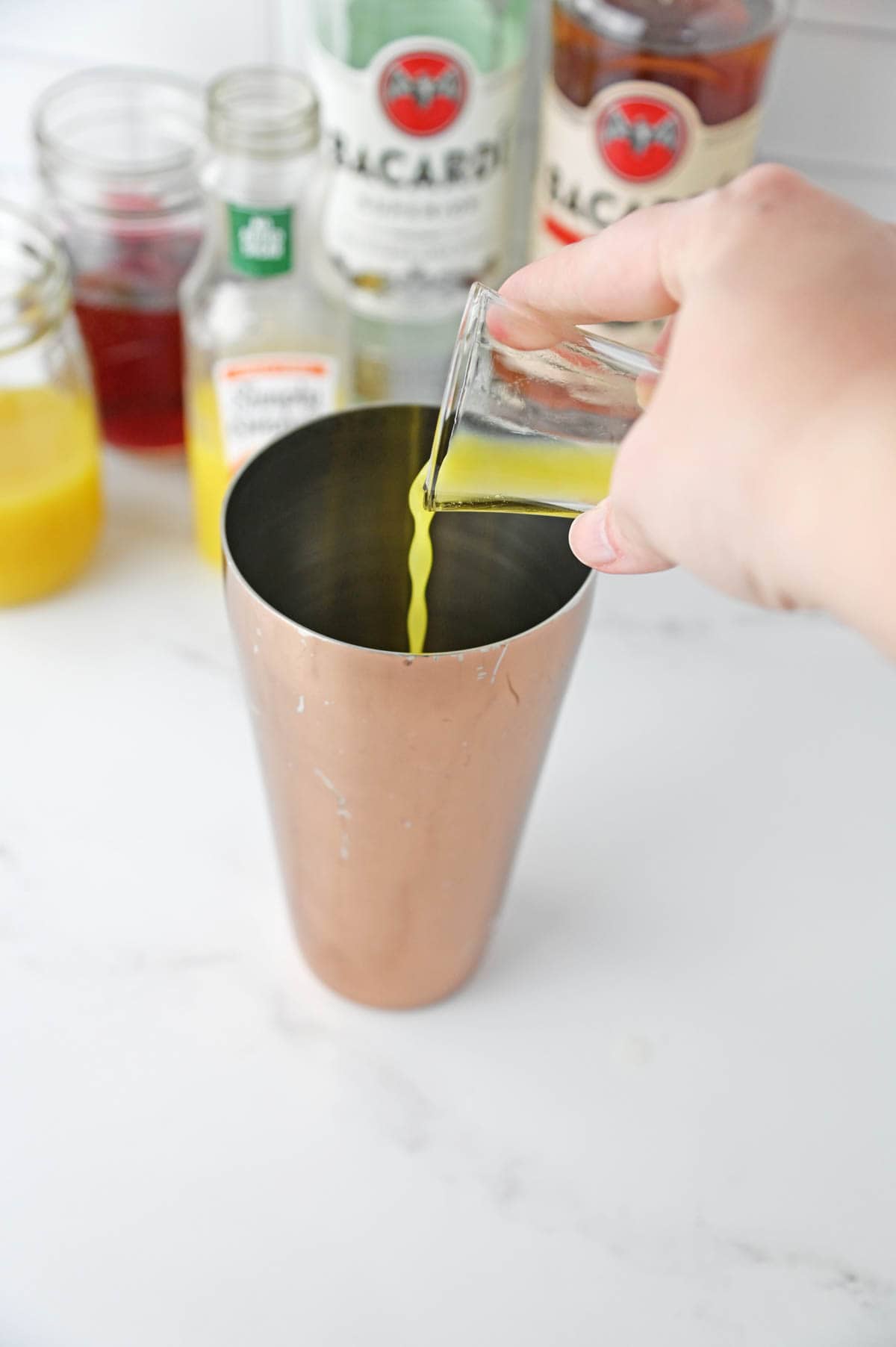 Adding orange juice to cocktail shaker