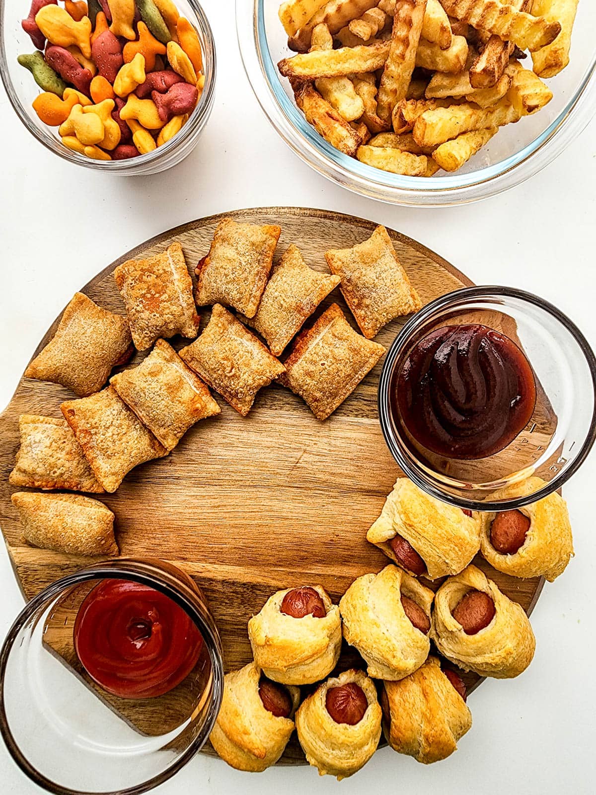 Pigs in a blanket on wooden board with pizza rolls