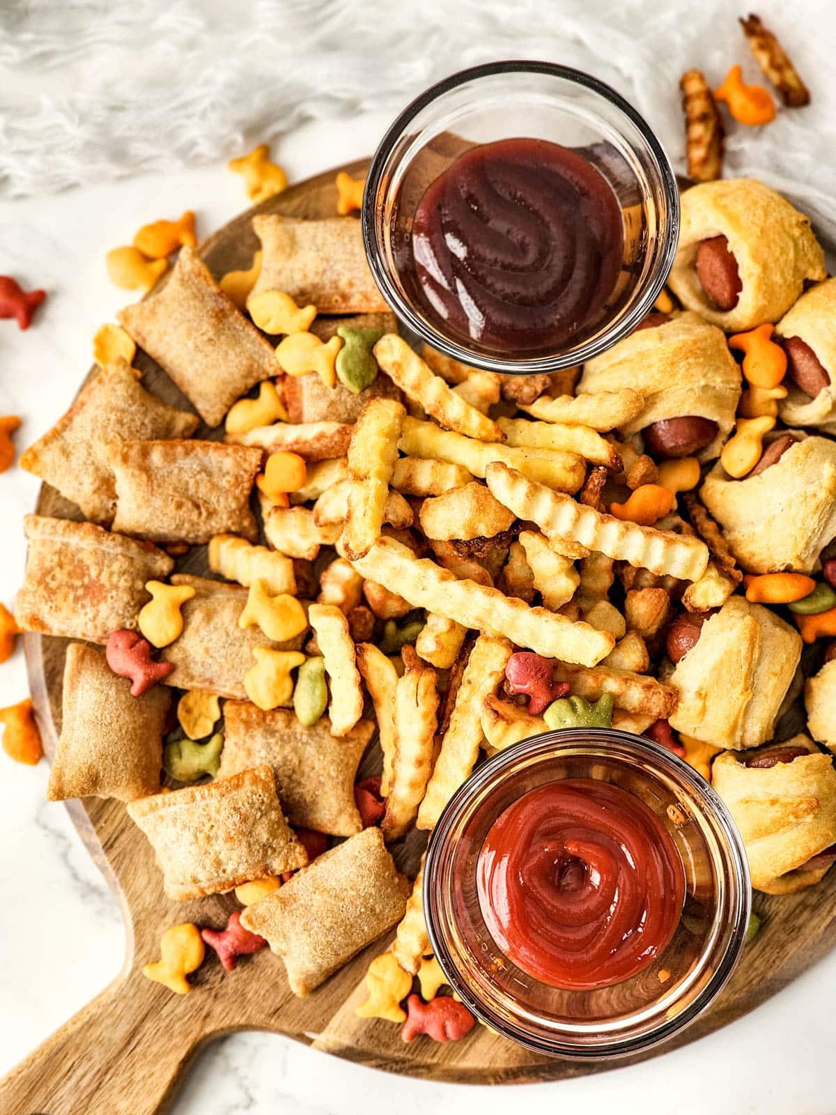 Kids charcuterie board with pigs in a blanket and pizza rolls
