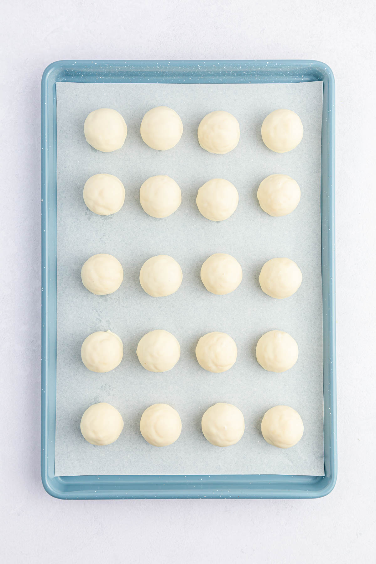 Cake balls with white chocolate on baking sheet