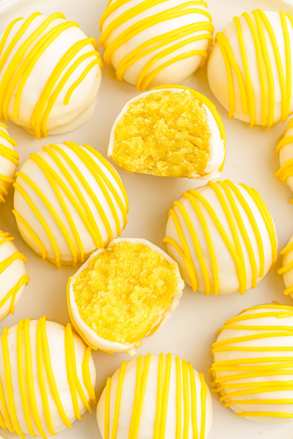 Lemon cake balls, some with bite taken out