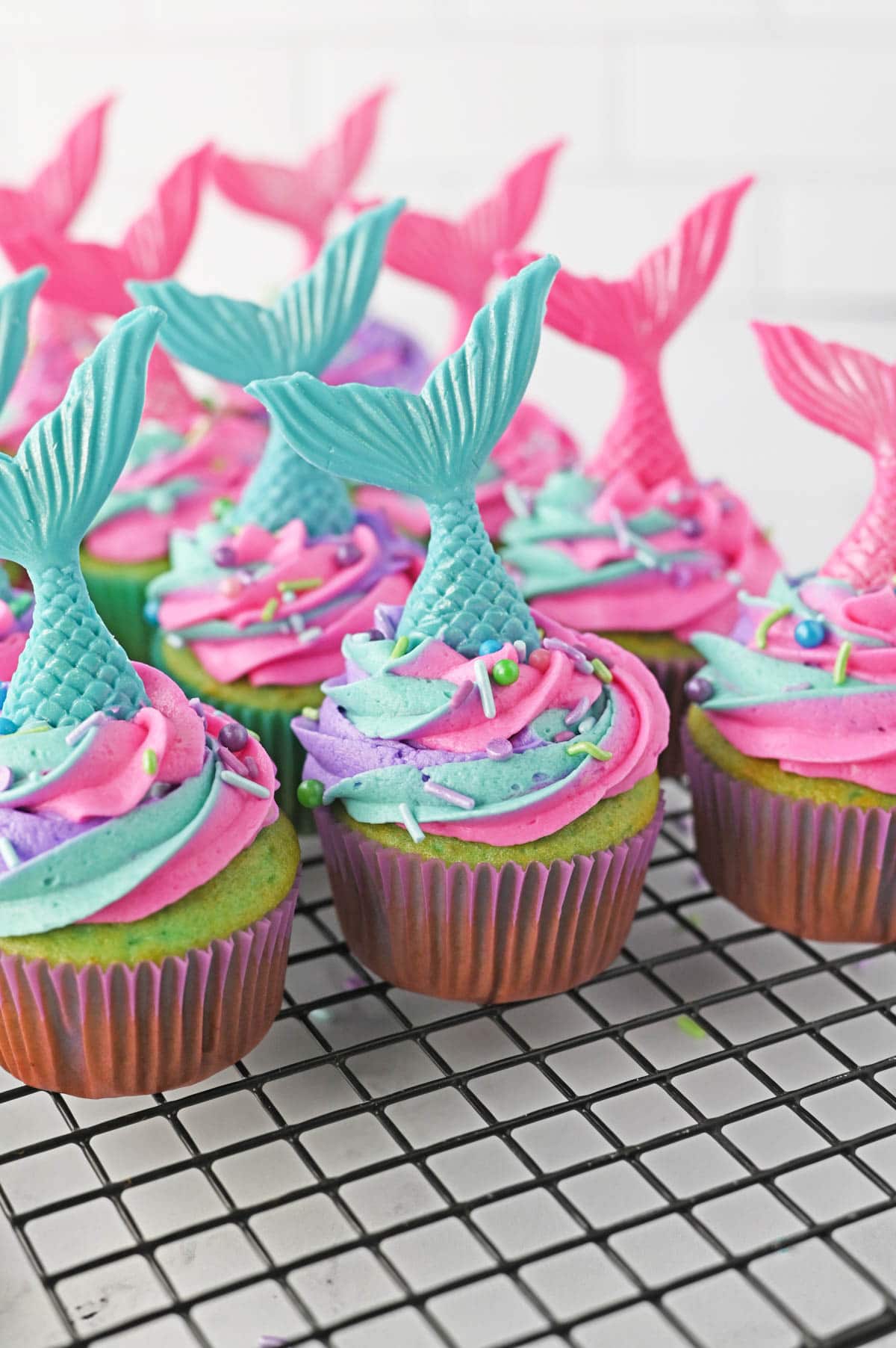 Cupcakes with mermaid sprinkles and mermaid tails sticking out the top