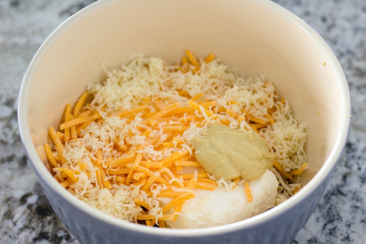 Sausage, cheeses and mustard in mixing bowl