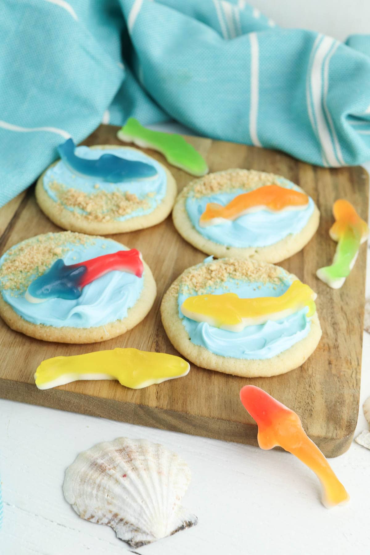 Shark cookie with gummy shark and graham cracker sand on wooden board