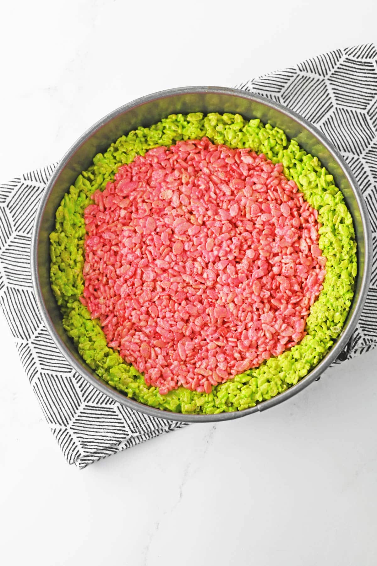 Red rice krispie mixture added to center of pan with green krispie treats