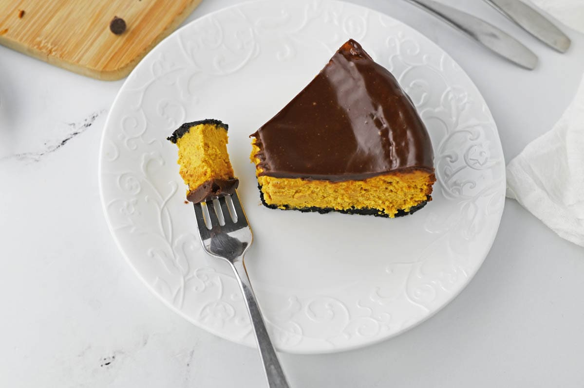 Pumpkin cheesecake on a fork on white plate