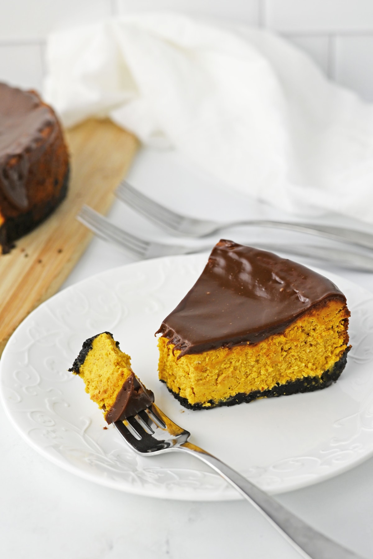 Chocolate pumpkin cheesecake on fork resting on white plate