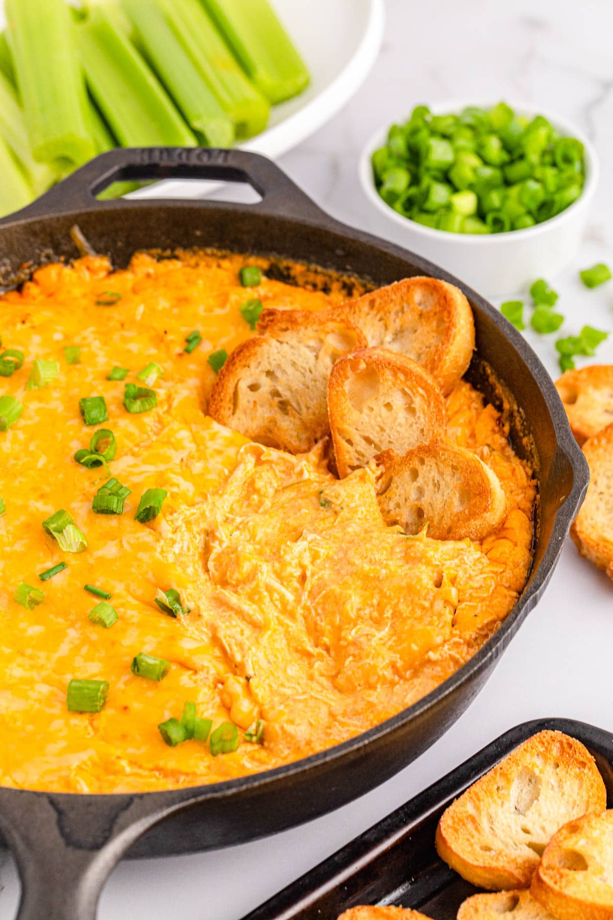 Buffalo chicken dip with toasted bread dipped in it
