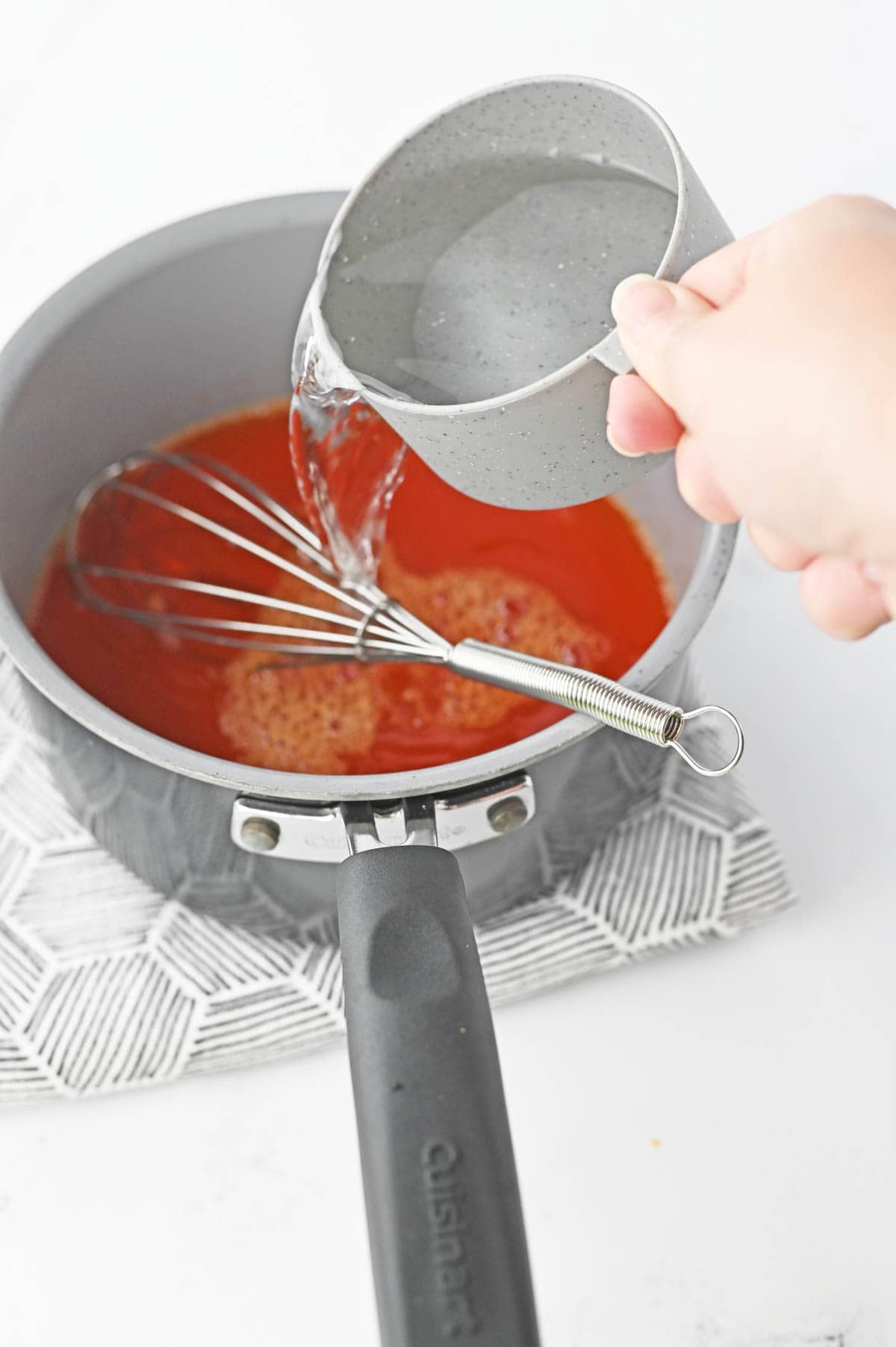 Pouring water into saucepan