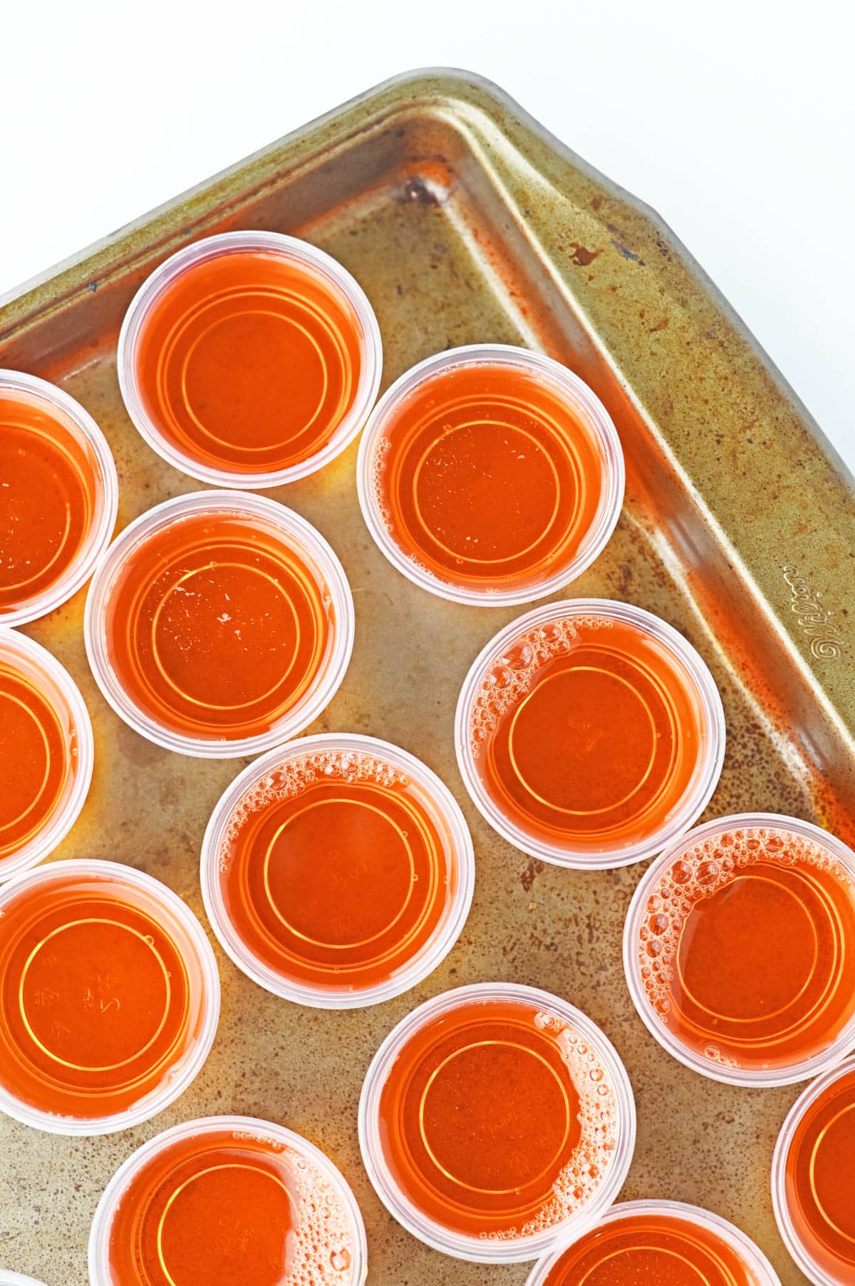Plastic jello cups filled with orange jello mix