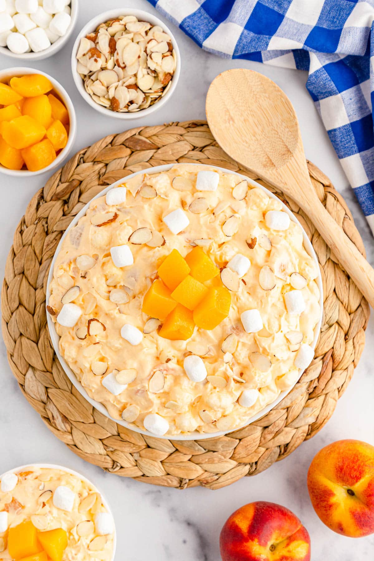 Bowl of peach fluff on a woven mat with blue checkered napkin