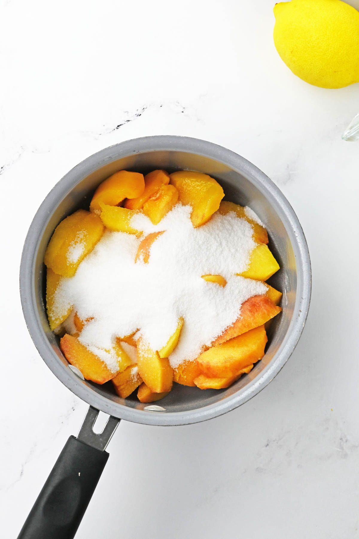 Peaches and sugar in saucepan