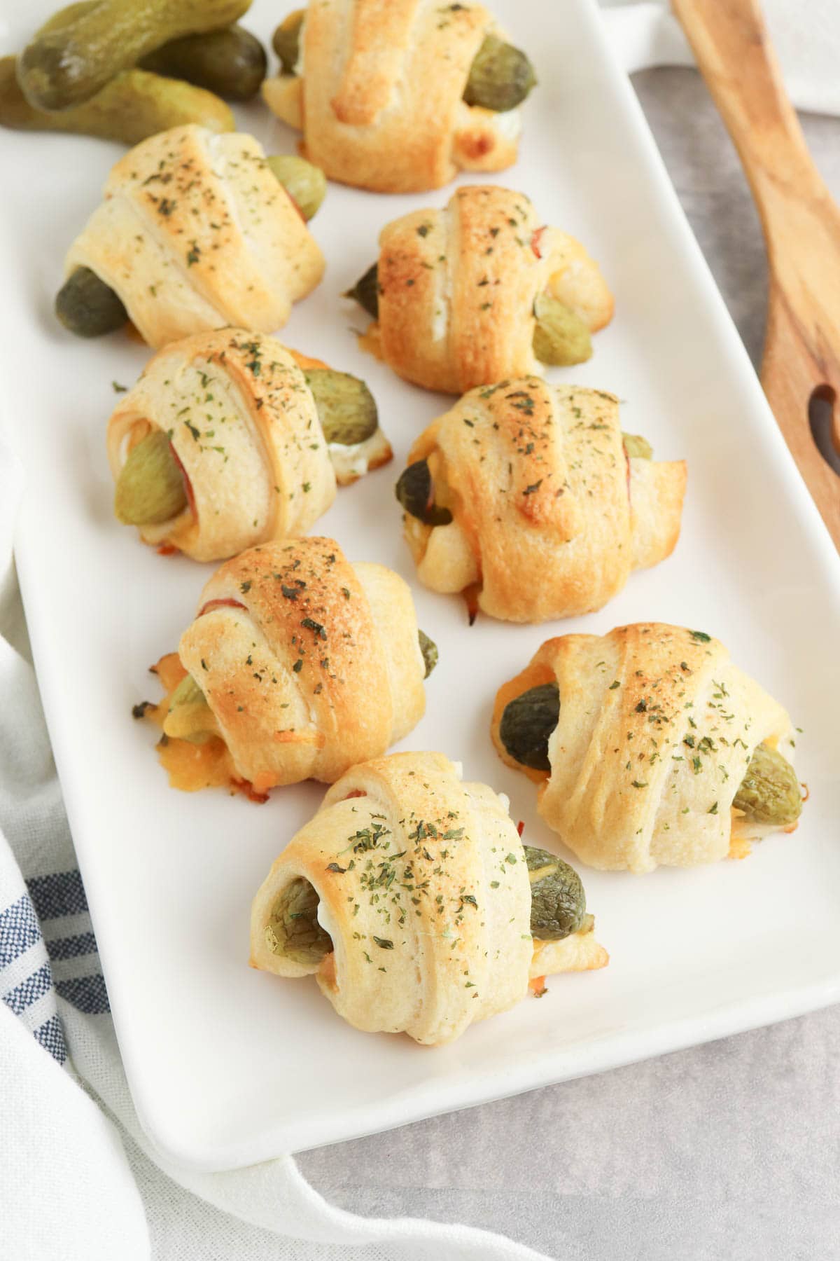 Pickles wrapped in crescent rolls on white plate