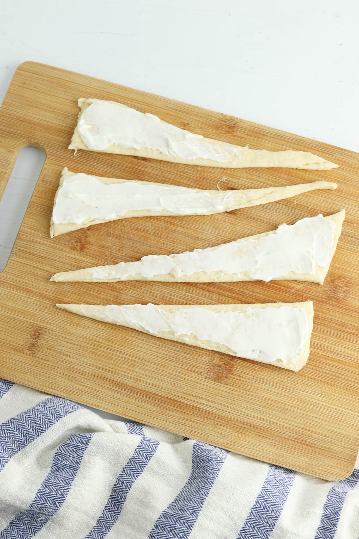 Cream cheese spread over uncooked crescent dough