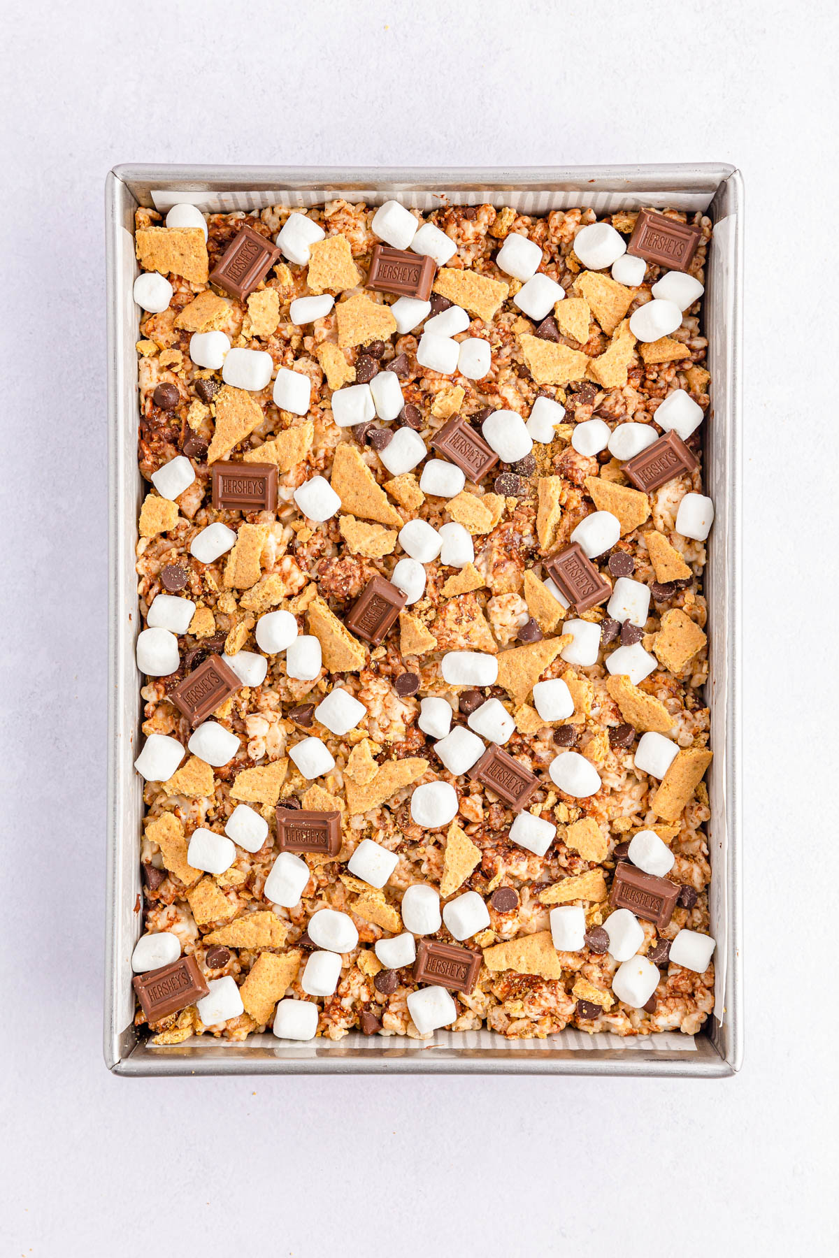 Smore's Rice Krispie Treats topped with chocolate, mini marshmallows and graham crackers