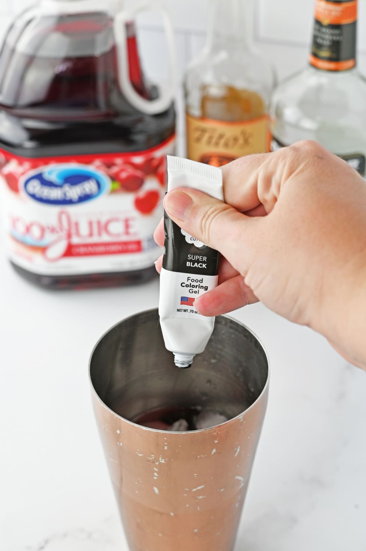 Black coloring gel being dripped into cocktail shaker
