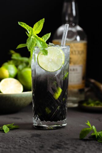 Black mojito with mint leaves and dark background