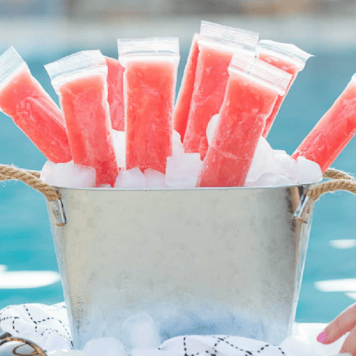 Boozy Watermelon Lemonade Popsicles in a metal ice bucket