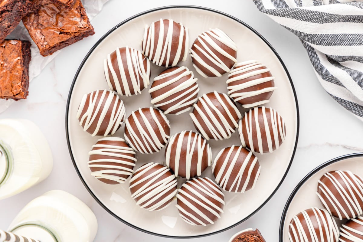 Brownie balls on white plate with black and white striped napkin