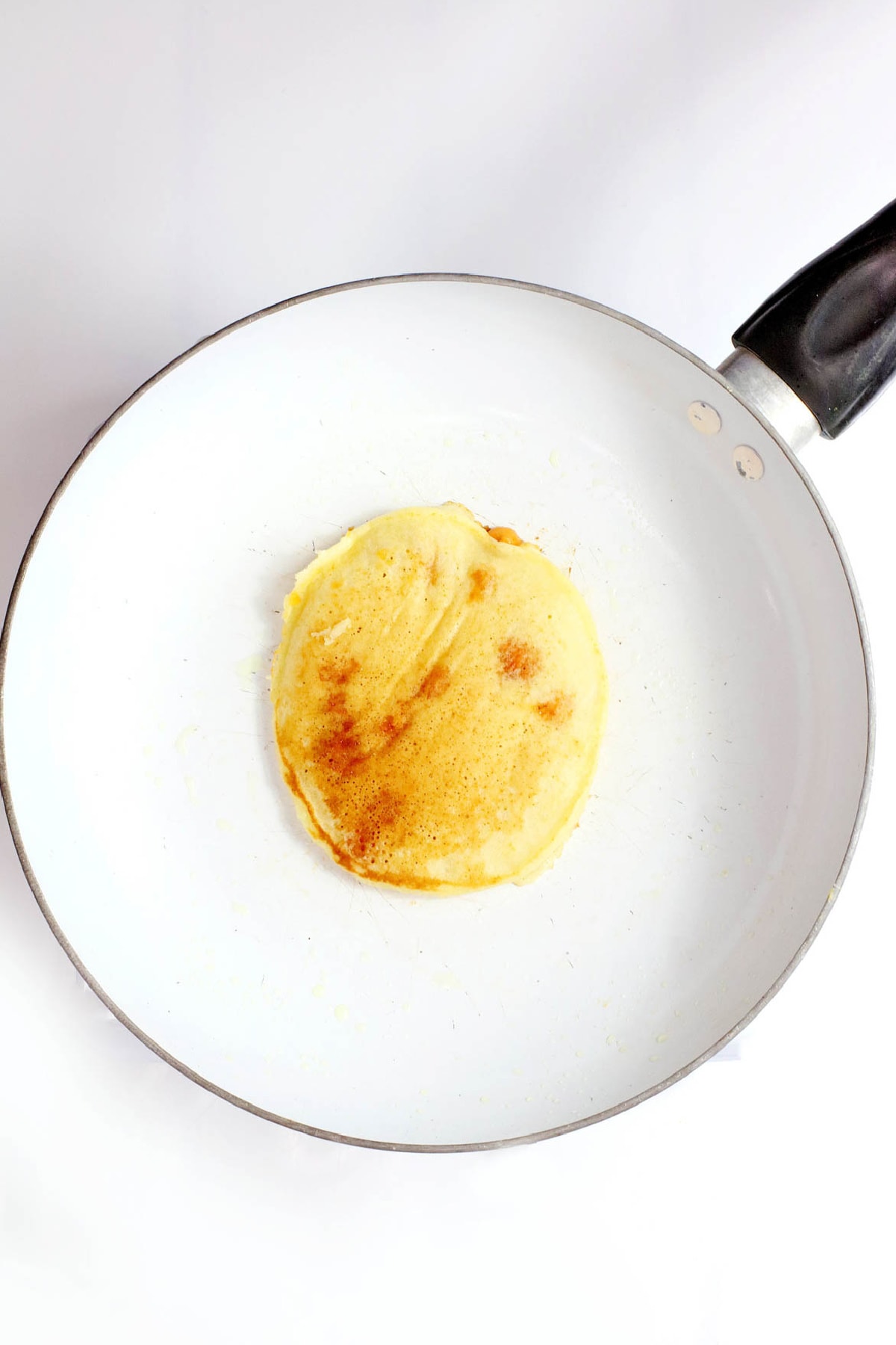 Pancake flipped in white skillet