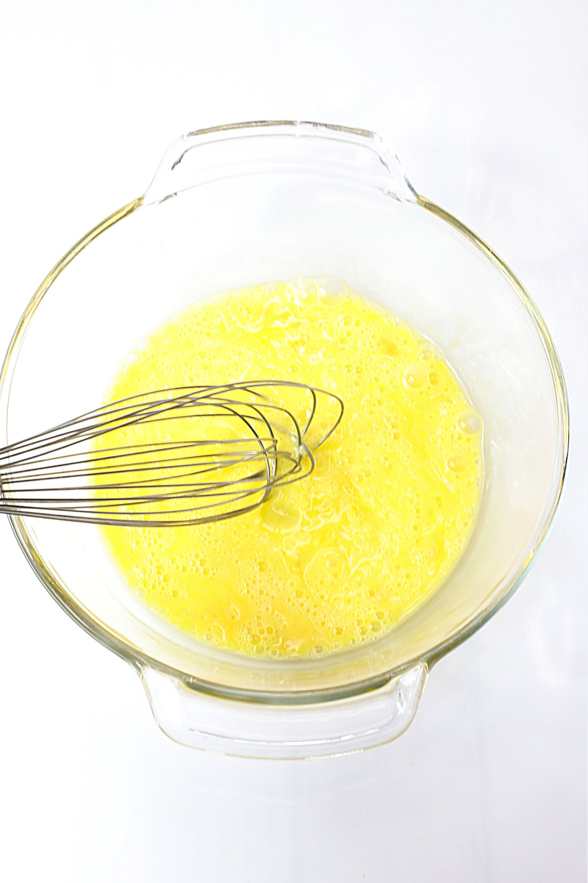Whisked eggs in glass bowl