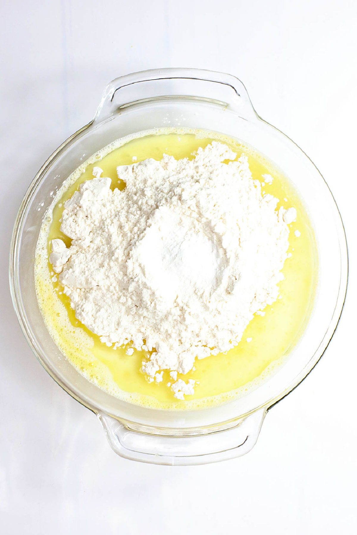 Flour added to egg and milk mixture in bowl