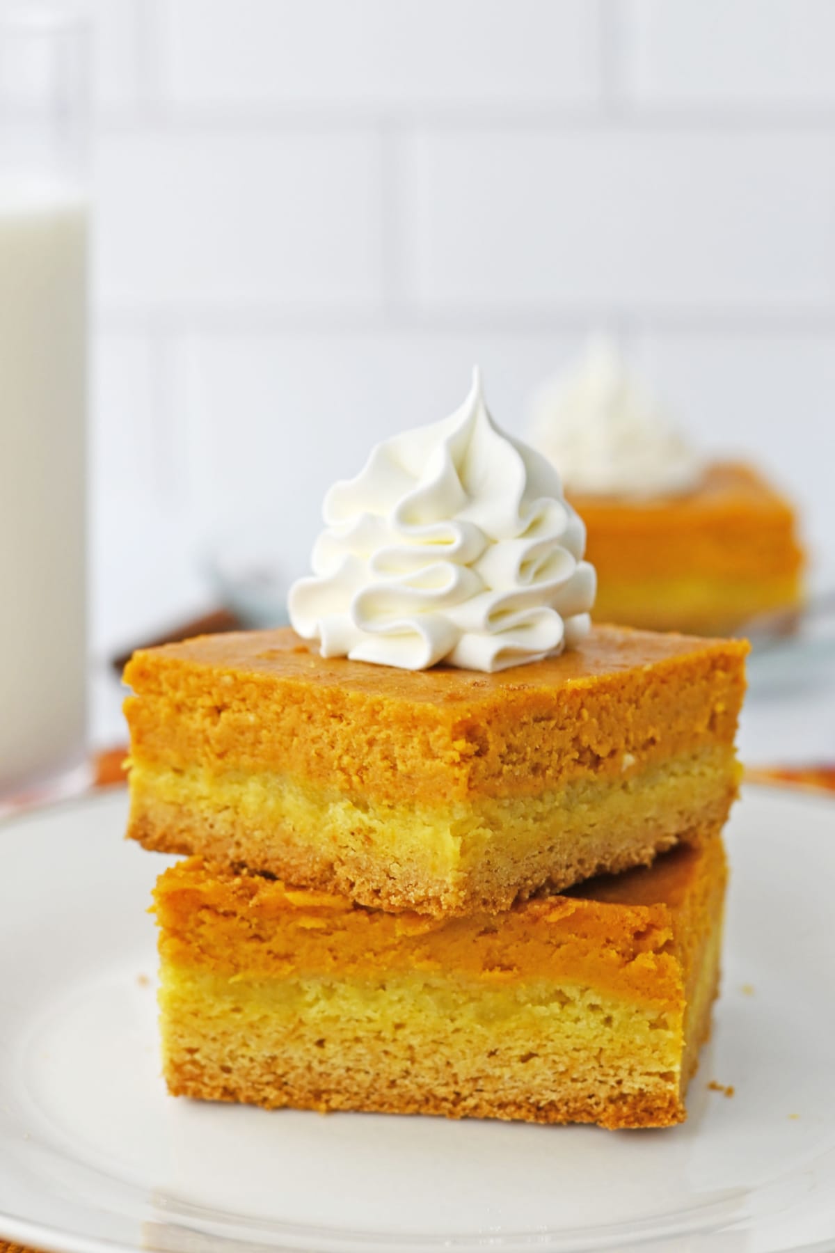 Cake mix pumpkin bars topped with whipped cream