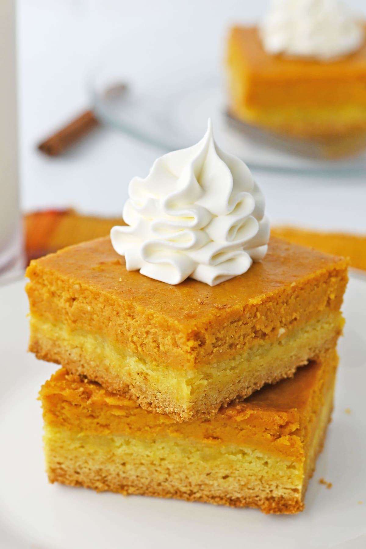 Cake Mix Pumpkin Bars stacked on white plate