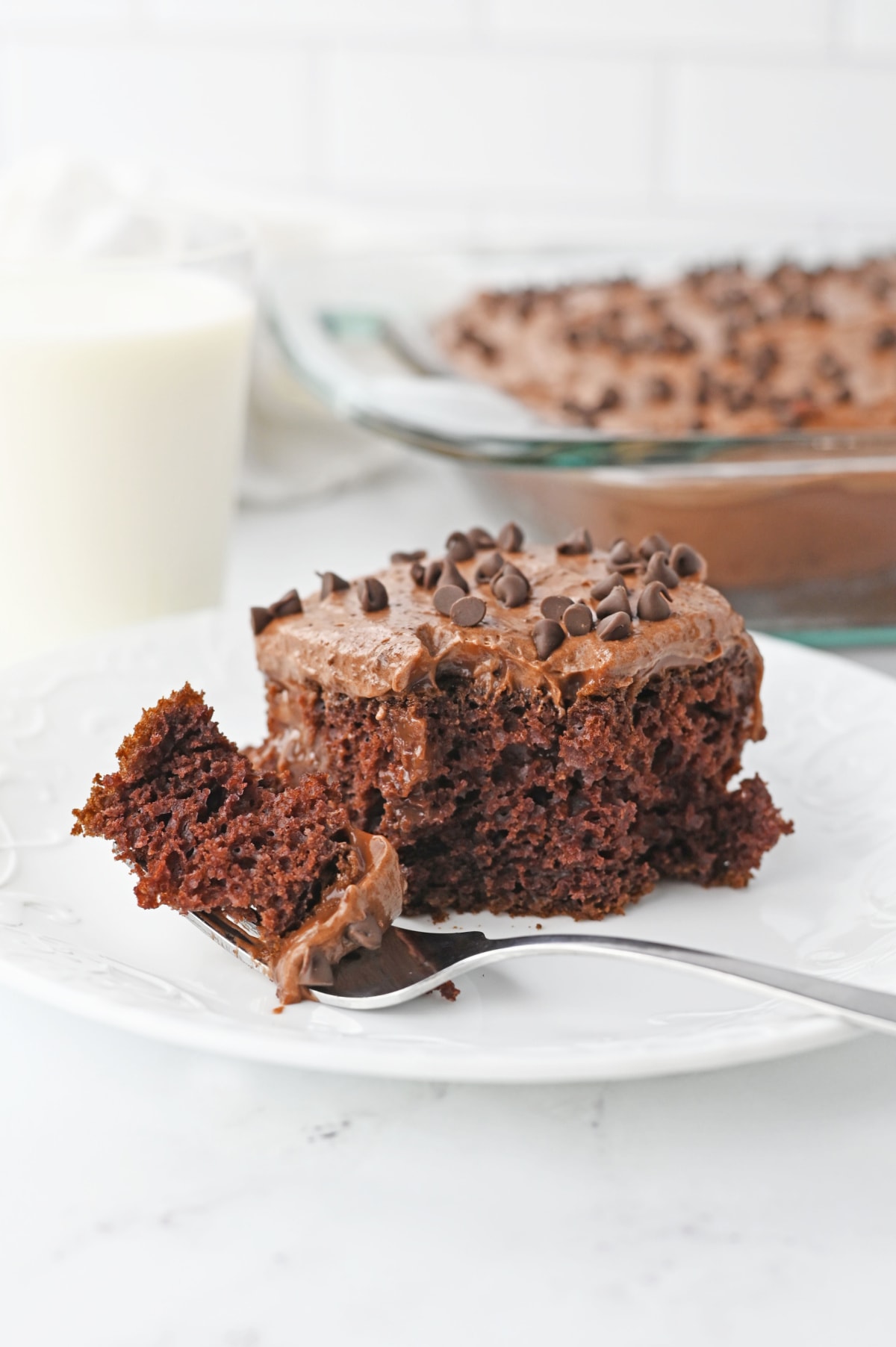 Chocolate poke cake with a piece on fork