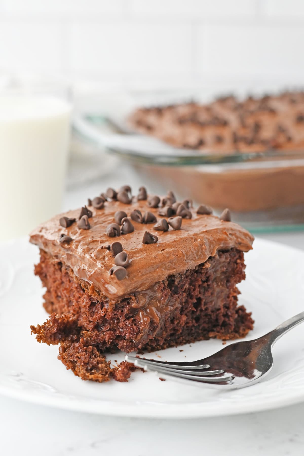 Chocolate poke cake on white plate